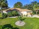 Beautifully landscaped front yard with mature trees, decorative rocks, and a well-maintained lawn at 13700 Se 90Th Ct, Summerfield, FL 34491