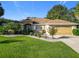 Charming single-story home featuring a well-manicured lawn and a two-car garage with clean landscaping at 13700 Se 90Th Ct, Summerfield, FL 34491