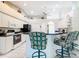 Bright kitchen featuring white cabinets, black appliances, with breakfast bar, seating, and tile flooring at 13700 Se 90Th Ct, Summerfield, FL 34491