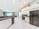 Spacious kitchen featuring white cabinets, black appliances, and tile flooring at 13700 Se 90Th Ct, Summerfield, FL 34491
