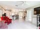 Open-concept living area featuring tile flooring, white ceiling fan, and access to the backyard at 13700 Se 90Th Ct, Summerfield, FL 34491