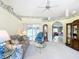 Bright living room featuring floral accents, ceiling fan, glass table, and sliding door to the outside at 13700 Se 90Th Ct, Summerfield, FL 34491