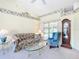 Cozy living room featuring carpet, patterned wallpaper border, comfortable seating and a grandfather clock at 13700 Se 90Th Ct, Summerfield, FL 34491