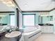 Bright main bathroom with double vanity, tile flooring, and large soaking tub beneath a window at 13700 Se 90Th Ct, Summerfield, FL 34491