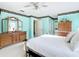Main bedroom with large dressers, windows, wall paper accents, and ensuite bathroom access at 13700 Se 90Th Ct, Summerfield, FL 34491