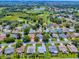 Aerial view of a residential neighborhood featuring lush landscaping, mature trees, and a nearby golf course at 1419 Arbor Trl, The Villages, FL 32162