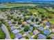 Aerial view of houses in a neighborhood with mature trees and a golf course in the background at 1419 Arbor Trl, The Villages, FL 32162