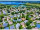 Aerial view of a neighborhood near a lake and a golf course, showcasing numerous homes and landscaping at 1419 Arbor Trl, The Villages, FL 32162