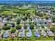 Aerial view of a residential neighborhood featuring lush landscaping, mature trees, and a nearby golf course at 1419 Arbor Trl, The Villages, FL 32162