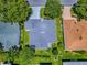 An aerial view of the house showing its roof, green lawn, landscaping, and a screened-in pool at 1419 Arbor Trl, The Villages, FL 32162