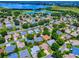 Aerial view of a neighborhood near a lake and a golf course, showcasing numerous homes and landscaping at 1419 Arbor Trl, The Villages, FL 32162