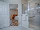 Bright bathroom showcasing a glass-enclosed shower and an open doorway to the bedroom at 1419 Arbor Trl, The Villages, FL 32162