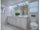 Bright bathroom featuring a dual sink vanity, a large mirror, and natural light from the window at 1419 Arbor Trl, The Villages, FL 32162