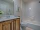 Bathroom featuring a wooden vanity with a sink, bathtub, and white tiles at 1419 Arbor Trl, The Villages, FL 32162