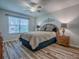 Cozy bedroom featuring a ceiling fan, bedside tables, and a window with natural light at 1419 Arbor Trl, The Villages, FL 32162