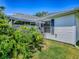 Charming home exterior with lush landscaping and a window with dark shutters at 1419 Arbor Trl, The Villages, FL 32162