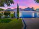 Charming one-story home at sunset, with well-manicured lawn and mature trees at 1419 Arbor Trl, The Villages, FL 32162
