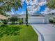 Charming one-story white home featuring a three-car garage and manicured lawn at 1419 Arbor Trl, The Villages, FL 32162