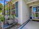 Inviting front porch detail with decorative wrought iron bench, flower pot, and a view of the front door at 1419 Arbor Trl, The Villages, FL 32162