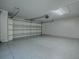 Spacious garage with epoxy flooring, built-in shelving, and an automatic door at 1419 Arbor Trl, The Villages, FL 32162