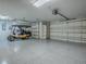 Well lit garage with two automatic doors, epoxy flooring and golf cart at 1419 Arbor Trl, The Villages, FL 32162
