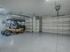 Well lit garage with two automatic doors, epoxy flooring and golf cart at 1419 Arbor Trl, The Villages, FL 32162