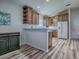 Open kitchen showcases wood cabinets and white appliances, seamlessly connecting with other living spaces for convenience at 1419 Arbor Trl, The Villages, FL 32162