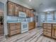 Well-lit kitchen features light wood cabinets, white appliances, and vinyl flooring, perfect for cooking and entertaining at 1419 Arbor Trl, The Villages, FL 32162