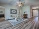 Bright living room with wood floors, a ceiling fan, neutral walls, and comfortable furniture at 1419 Arbor Trl, The Villages, FL 32162