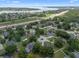 This aerial showcases a residential neighborhood with mature trees, well maintained lawns, and nearby lake and highway access at 14708 Timucua Pl, Clermont, FL 34711
