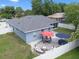 Aerial view of the backyard showcasing a patio with umbrellas, a fire pit, and a white privacy fence at 14708 Timucua Pl, Clermont, FL 34711