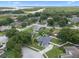 An aerial view of the property in its neighborhood, showcasing a beautiful location near a lake, lush greens, and well-kept lawns at 14708 Timucua Pl, Clermont, FL 34711