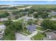 This is an aerial view of a property in a neighborhood near a lake with lush green trees and manicured lawns at 14708 Timucua Pl, Clermont, FL 34711