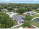 Aerial view of a house in a neighborhood, boasting lush greenery, a well-kept lawn, and outdoor living space with a patio set at 14708 Timucua Pl, Clermont, FL 34711