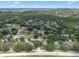 Aerial view of a beautiful residential neighborhood featuring tree-lined streets, ponds, and verdant landscaping on a sunny day at 14708 Timucua Pl, Clermont, FL 34711