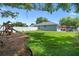 Well-maintained backyard with a lush lawn, a playground, a patio, and a white privacy fence at 14708 Timucua Pl, Clermont, FL 34711