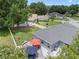 Aerial view of a backyard featuring a patio area, fire pit, playset, a white fence, and mature trees at 14708 Timucua Pl, Clermont, FL 34711