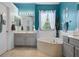 Tranquil bathroom with tub and vanity, complemented by blue walls and bright lighting at 14708 Timucua Pl, Clermont, FL 34711