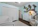 Bright Bedroom featuring blue walls, shelving, and a white crib at 14708 Timucua Pl, Clermont, FL 34711