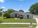 Charming single-story home featuring a red front door, well-manicured lawn, and mature landscaping at 14708 Timucua Pl, Clermont, FL 34711