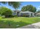 Well-maintained single-story home with mature trees and shrubs, offering shade and curb appeal at 14708 Timucua Pl, Clermont, FL 34711