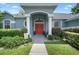 Inviting entryway showcasing a red double door, classic columns, and beautiful landscaping at 14708 Timucua Pl, Clermont, FL 34711