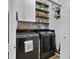 Efficient laundry room features front-loading machines and stylish shelving with decorative wallpaper at 14708 Timucua Pl, Clermont, FL 34711