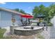 Cozy patio area complete with a firepit, patio furniture set, and manicured landscaping at 14708 Timucua Pl, Clermont, FL 34711
