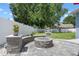 Inviting backyard patio with a stylish fire pit, manicured plants, and privacy fence at 14708 Timucua Pl, Clermont, FL 34711