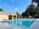 Relaxing community pool area with clear blue water, lounge chairs, and a covered gazebo on a sunny day at 14708 Timucua Pl, Clermont, FL 34711
