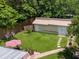 Aerial shot of the backyard with a shed, patio set with umbrella, green lawn, and stepping stone pathway at 1537 Ne 22Nd St, Ocala, FL 34470
