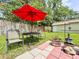 Well-maintained backyard with a red umbrella over an outdoor dining set, garden decorations, and a storage shed at 1537 Ne 22Nd St, Ocala, FL 34470