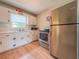 Bright kitchen with stainless steel appliances, tiled countertops, and wood-look floors at 1537 Ne 22Nd St, Ocala, FL 34470