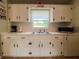 Bright kitchen with white cabinets and tiled countertops, and a window view at 1537 Ne 22Nd St, Ocala, FL 34470